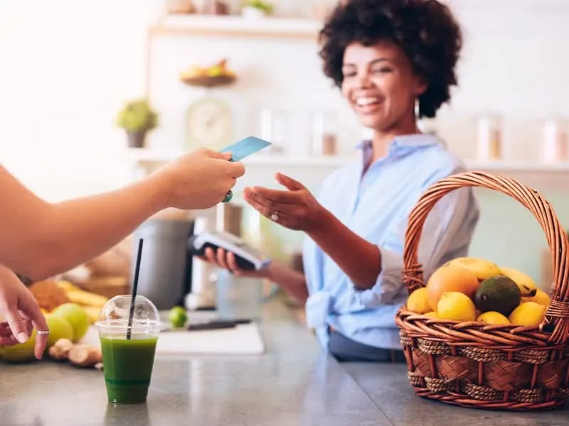 Small business owner accepting a credit card payment from a customer in her store