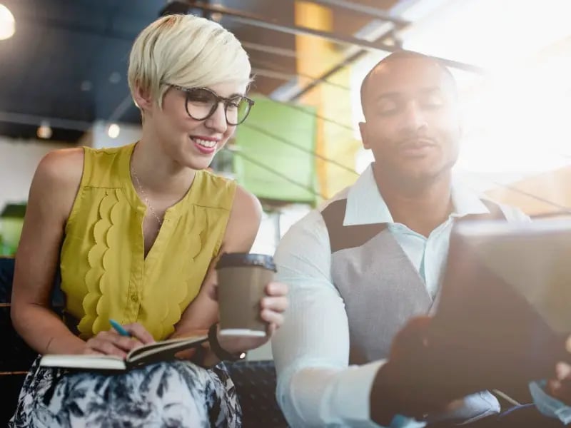 Deux propriétaires de petites entreprises en train de regarder leur tablette