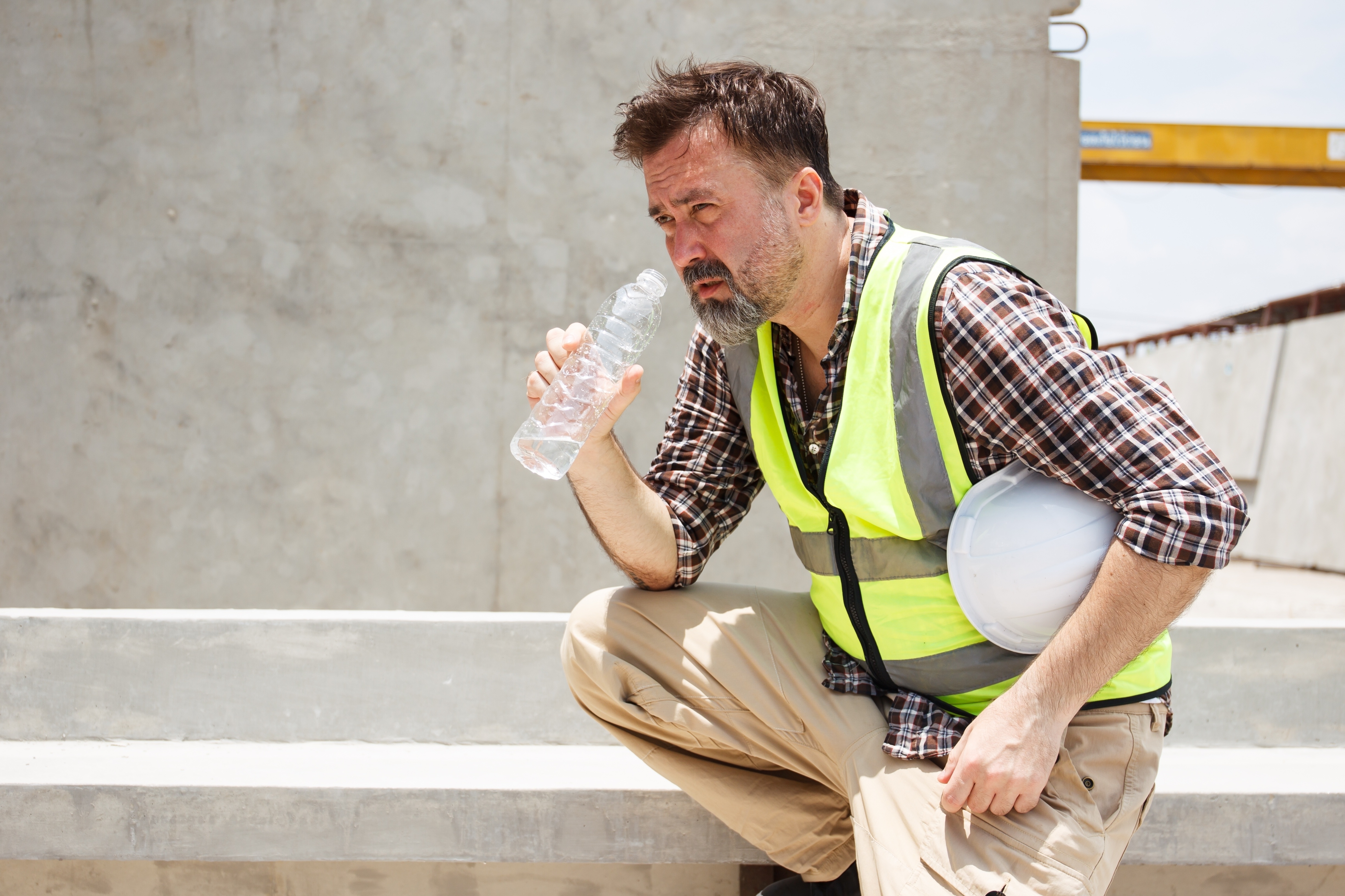 worker outside in heat about to drink water