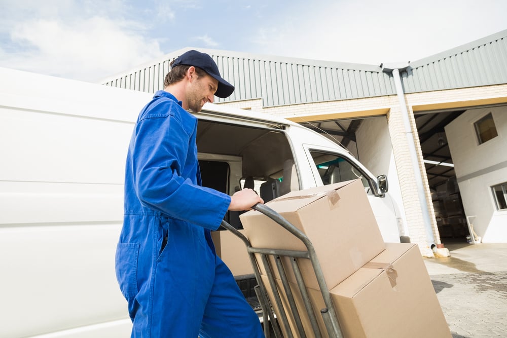 Delivery driver packing his van in a large warehouse