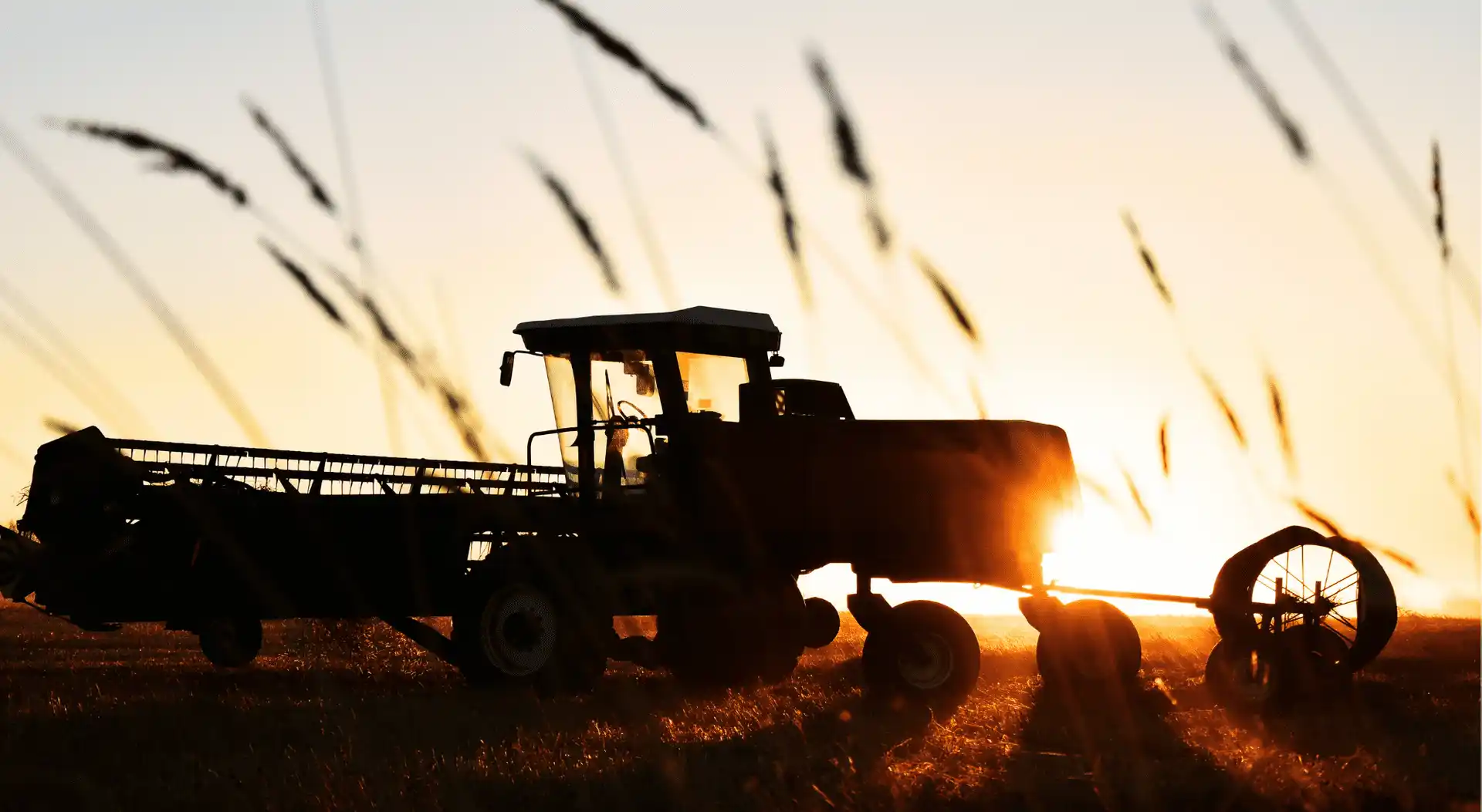 Tractor parked in a field during sunset