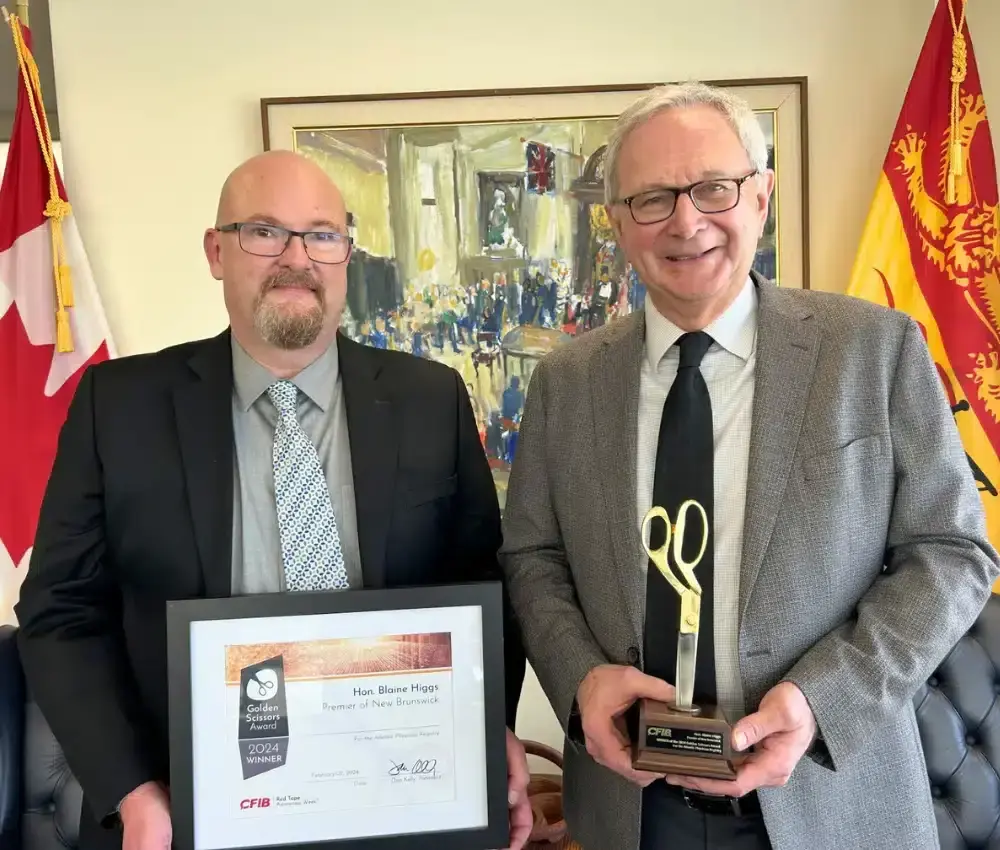 Louis-Philippe Gauthier, Vice-président, Atlantique à la FCEI, remet le Prix Ciseaux d’or au premier ministre de Nouveau-Brunswick, Blaine Higgs