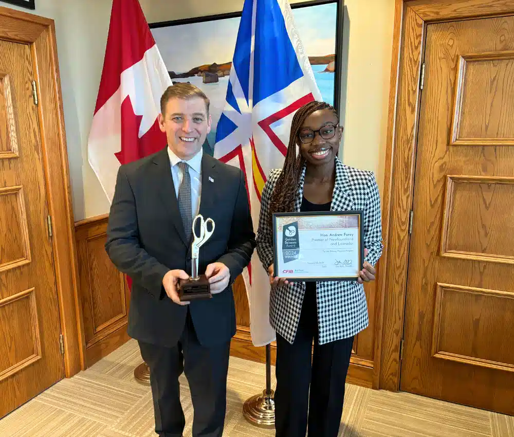 Beatrix Abdul Azeez, analyste des politiques à la FCEI, remet le Prix Ciseaux d’or au premier ministre de Terre-Neuve-et-Labrador, Andrew Furey
