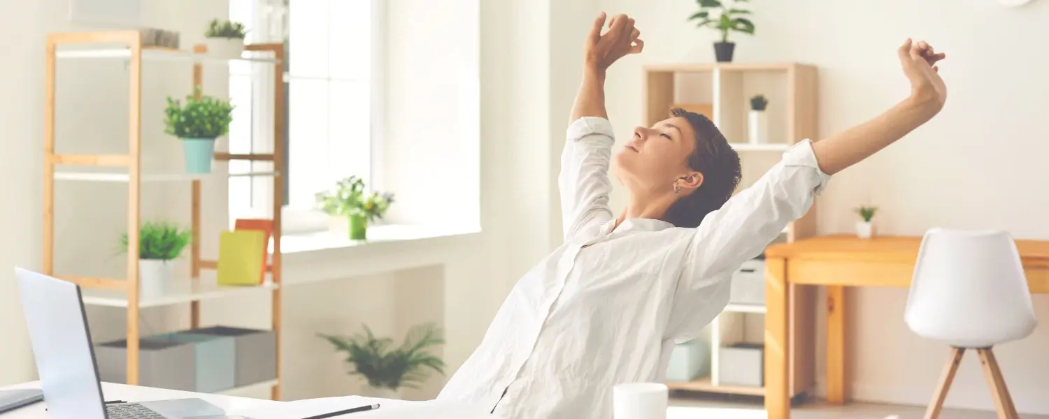 Small business owner performing stretching exercises at her desk