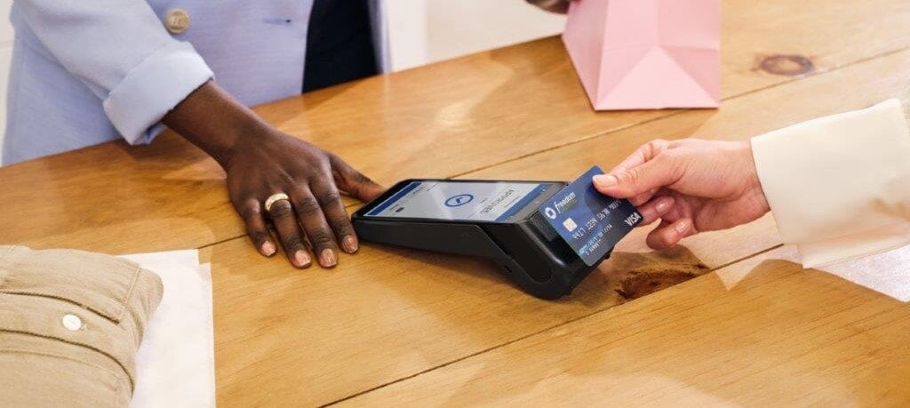 Small business owner accepting credit card payments from one of her customers using Chase's POS terminals