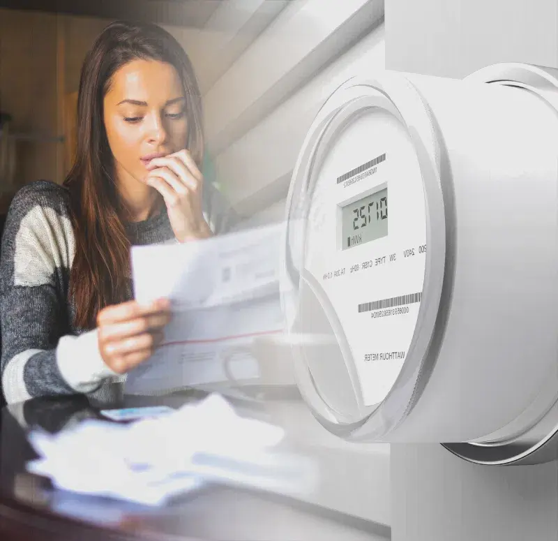 Image of a worried small business owner reading her electricity bill beside an electricity counter