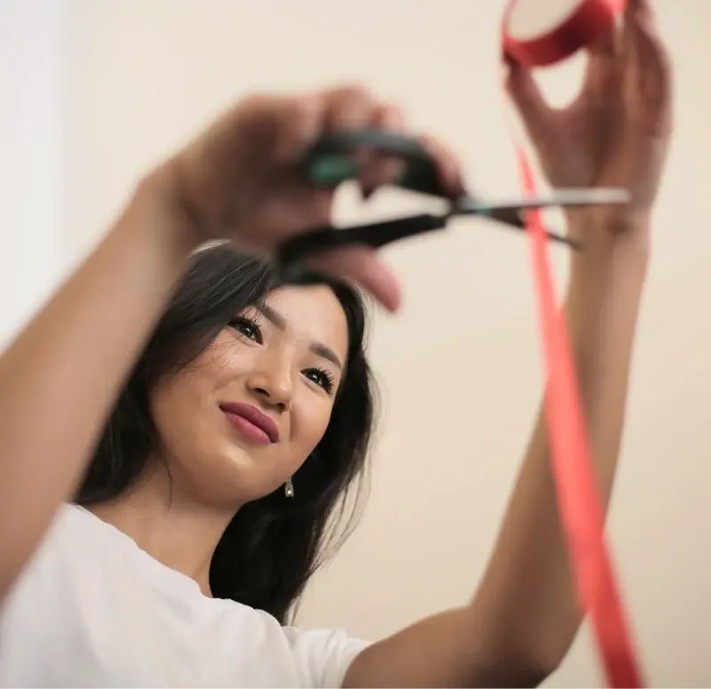 Small business owner cutting a red tape with scissors