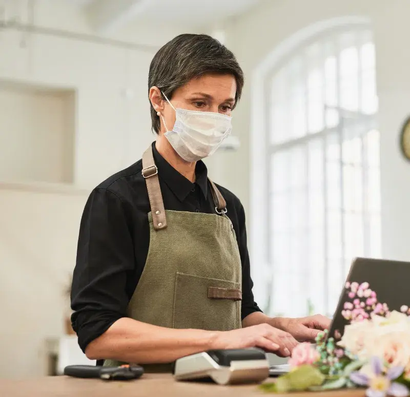 Small business owner wearing a mask in her shop